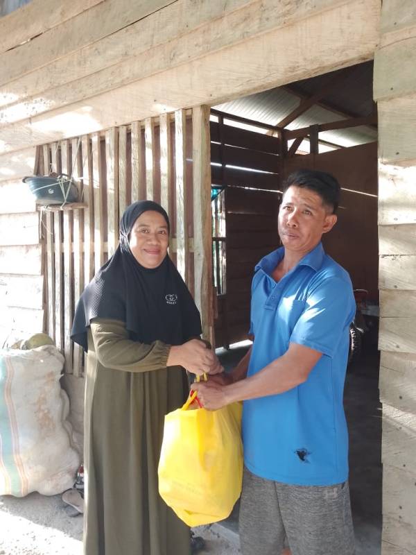 Ketgam: Perwakilan alumni SMPN 1 Unaaha, Hasriani (kiri) menyerahkan paket THR dari donasi para alumni kepada salah seorang warga Lasada, Kelurahan Tuoy, Selasa (17/3/2026).